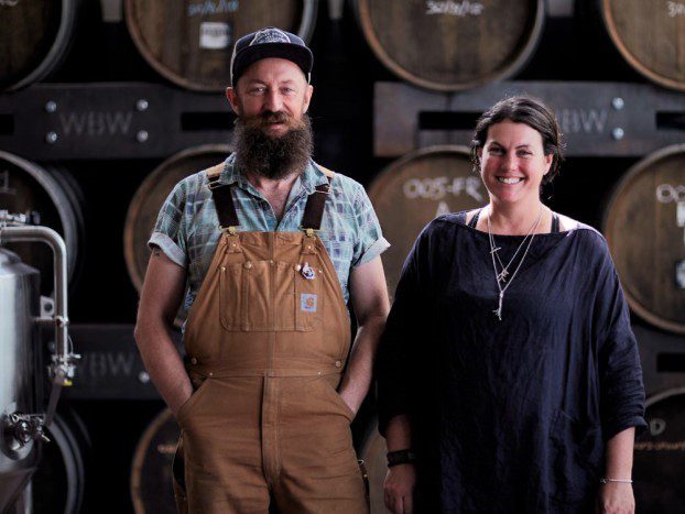 two people standing in a beer cellar smiling